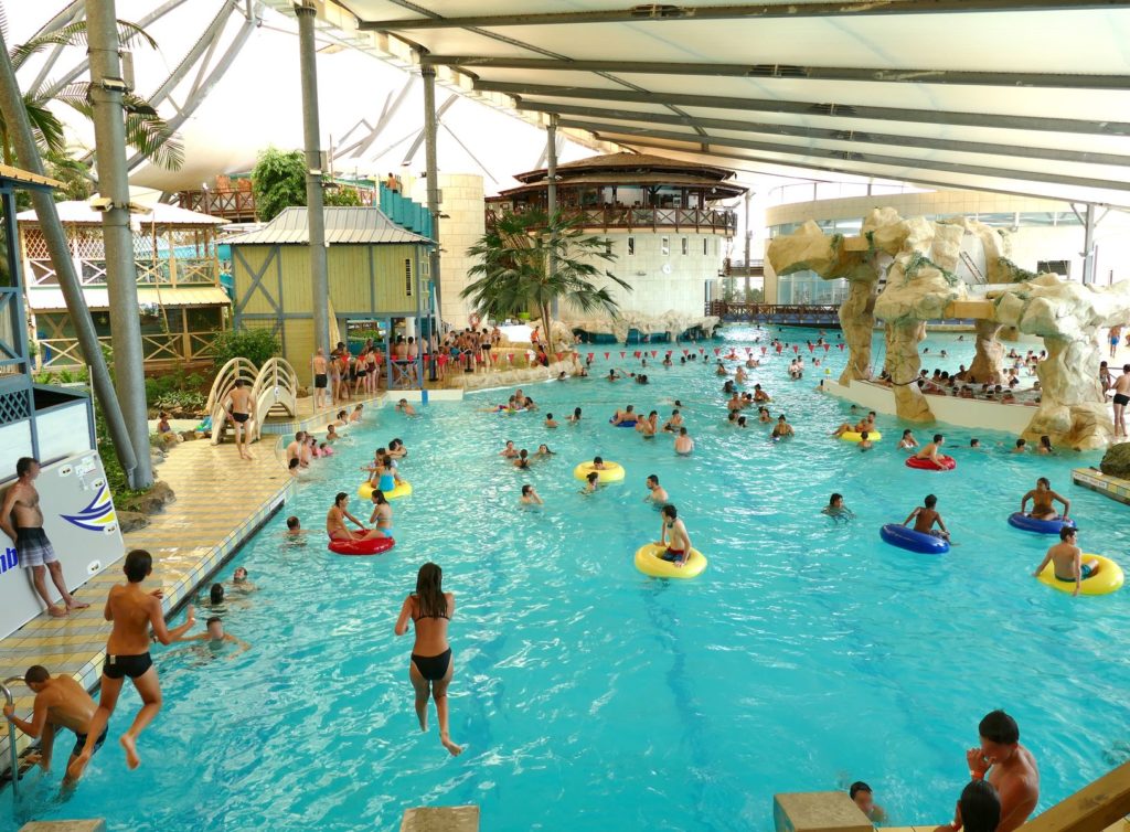 Photo de nombreux baigneurs s'amusant dans la piscine intérieure des Antilles de Jonzac un jour de vacances scolaires